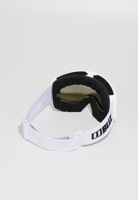 Lunettes de ski blanches avec rembourrage en mousse noire et sangle réglable, marquées "BLIZ" en lettres noires sur fond blanc.