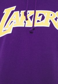 Felpa viola con il testo "Lakers" in giallo e bianco e stringhe viola con estremità annodate.