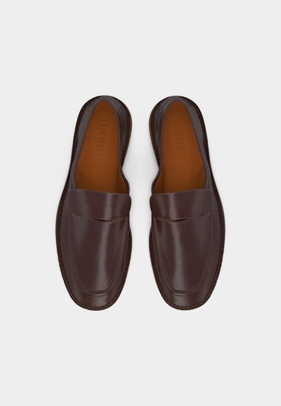 Mocassins en cuir marron foncé à enfiler, avec bouts carrés arrondis et détails de coutures minimaux, vus de dessus sur un fond uni.