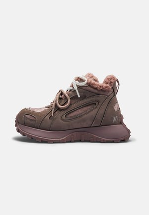 Brązowy sneaker za kostkę z grubą podeszwą, teksturowaną podeszwą zewnętrzną, mieszanymi kolorami sznurowadeł i różowym puszystym podszyciem widocznym wokół kołnierza wokół kostki.