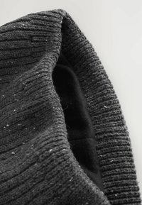 Ciemnoszara dzianinowa czapka beanie o strukturze ścięgien, z miękkim czarnym podszyciem i drobnymi kropeczkami jaśniejszego koloru w całej tkaninie.