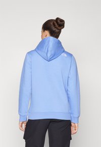 Felpa con cappuccio di colore azzurro chiaro realizzata in materiale morbido, dotata di un ampio cappuccio e di un piccolo logo sul retro vicino al collo.