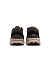 Zwarte en grijze sneakers met een gestructureerde bovenkant, voorzien van mesh-accenten en een gepolsterde schacht. De lichte beige zool heeft een rubberen basis.