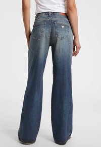 Wijde denim jeans in een verloopblauwe wassing, met een hoge taille, achterzakken en een leren logo-patch op de achterkant.