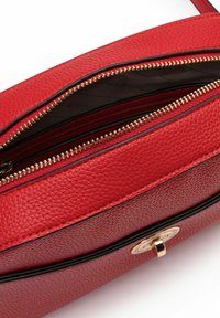 Bolso de mano de cuero rojo con textura de piedras, con un cierre de cremallera dorada, forro interior negro y un cierre de hardware dorado en la parte frontal.