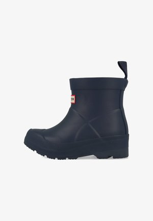 Marine rubberen enkelboot met een gestructureerde zool, ronde neus, verhoogde hak en een trekband aan de achterkant; voorzien van een klein logolabel aan de zijkant.