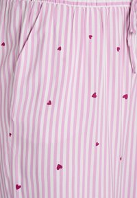 Lightweight pink sleep shorts with vertical white stripes and scattered dark pink heart patterns. Features an elastic waistband and pockets.