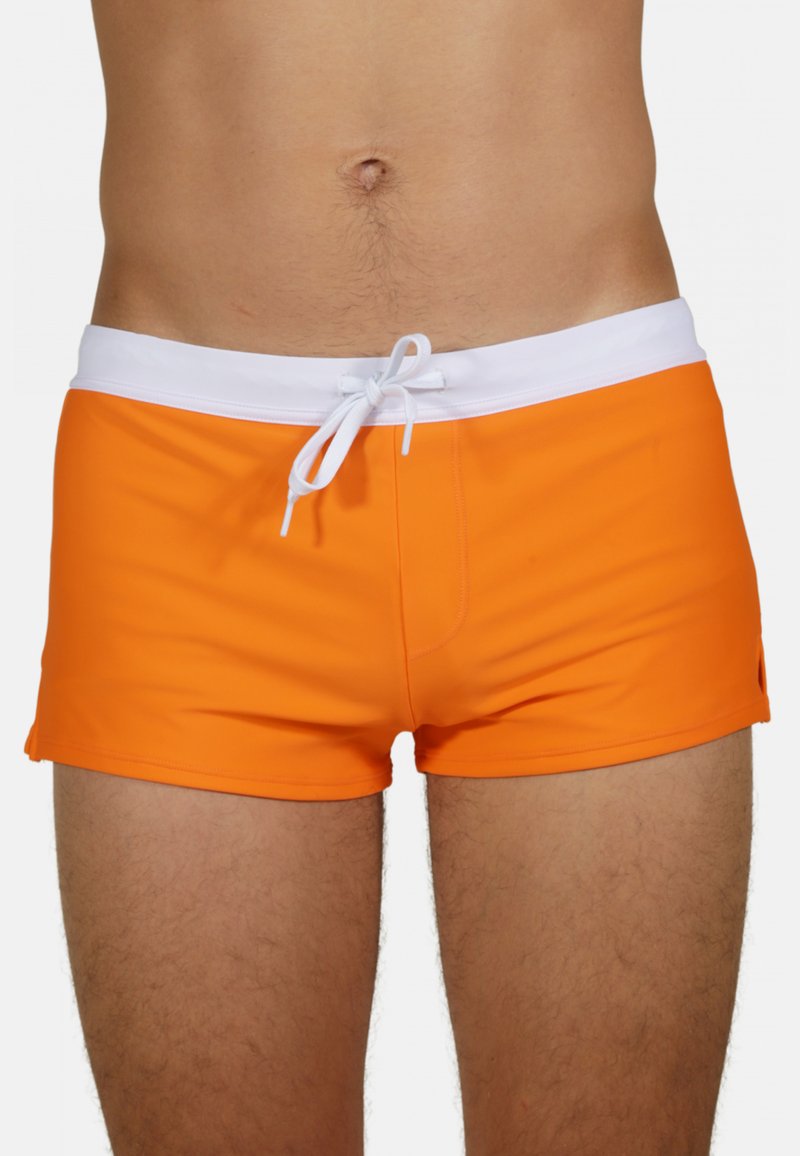 Shorts de bain orange vif avec un cordon de serrage blanc à la taille, offrant une coupe ajustée et une texture lisse. Aérations latérales pour le confort et la liberté de mouvement.