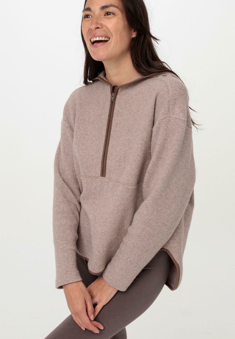 Pullover in fleece marrone chiaro con colletto alto e zip a metà, caratterizzato da una vestibilità comoda e maniche lunghe, da abbinare a leggings scuri.