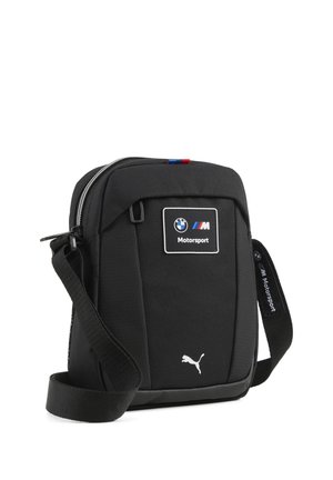 Sac bandoulière noir avec logos BMW Motorsport et Puma, bandoulière ajustable et compartiment principal zippé.
