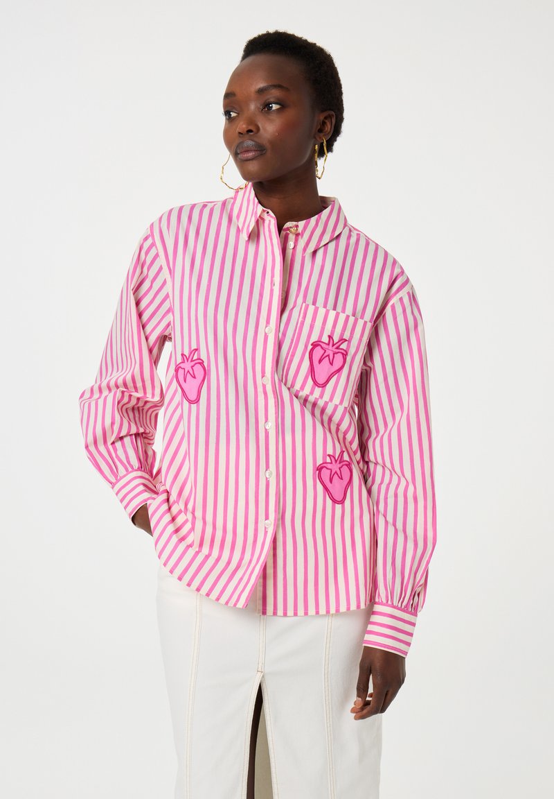 Pink and white striped button-up shirt with embroidered strawberry designs on the chest and pocket. Features loose fit and long sleeves.