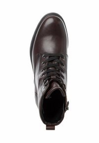 Bottine en cuir marron avec des lacets noirs, un bout arrondi et une languette à l'arrière ; texture lisse avec un brillant subtil.