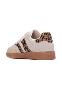 Zapatillas de ante beige con acentos de estampado de leopardo, suela de goma plana marrón y cierre con cordones. Presenta paneles texturizados y detalles de costura.