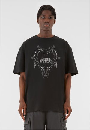 Sort bomulds oversized t-shirt med korte ærmer, der har et sølvfarvet hjerte designet af tornlignende grene og tekst i fed typografi.