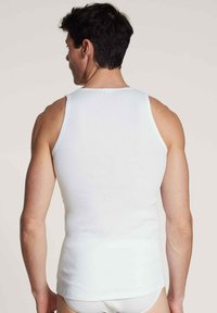 Witte katoenen tanktop met geribbelde textuur en een ronde hals, voorzien van een aansluitend ontwerp en brede schouderbanden.