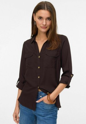 Brown, long-sleeve shirt with two chest pockets, button-down front, and roll-up sleeves. Features gold buttons and a relaxed fit.