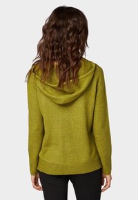 Grüner Kapuzenpullover mit strukturierter Strickoptik, lockerem Schnitt und geripptem Saum. Die Rückseite zeigt eine große, weiche Kapuze.