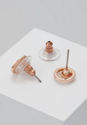 Drei Ohrstecker aus roségoldfarbenem Metall und klarem Kunststoff auf weißer Oberfläche dargestellt.