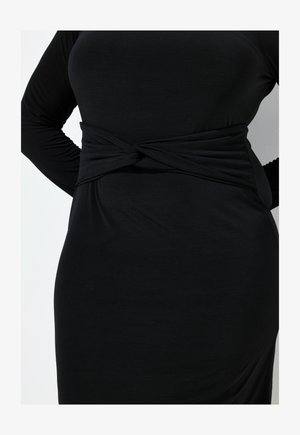 Abito lungo nero a maniche lunghe con dettaglio a nodo torcigliato in vita. Realizzato in un tessuto morbido ed elasticizzato con una silhouette aderente.