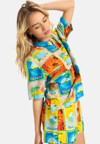 Short-sleeve shirt and shorts set in a colorful, tropical print featuring scenes of Tahiti, with blue, orange, yellow, and green tones.