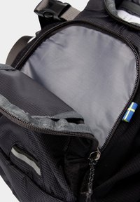 Schwarzer Nylon-Rucksack mit einem Reißverschluss-Öffnung, grauem Innenfutter und einem kleinen blauen und gelben Akzent. Verfügt über eine strukturierte Oberfläche und verstellbare Träger.