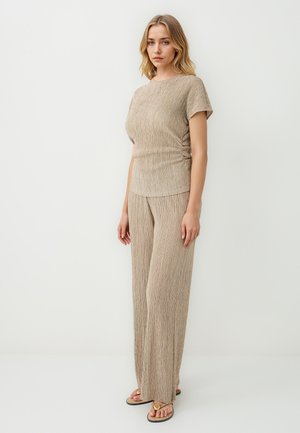 Beige geripptes Strickoberteil und weite Hosen im Set, mit strukturiertem Oberflächenmaterial und kurzen Ärmeln. Akzentuiert mit dezenten metallischen Fäden.