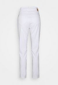 Bílé denimové džíny s rovnými nohavicemi. Mají dvě zadní kapsy a decentní logo na pásu. Hladká textura látky.