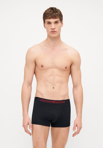 Des boxers briefs en coton noir avec une ceinture élastique portant le logo rouge "Emporio Armani", conçus pour une silhouette ajustée.