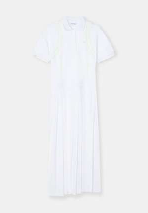 Rochie albă de stil polo, cu mâneci scurte, fustă plisată și accente neon verzi pe cusături. Fabricată dintr-un material neted.