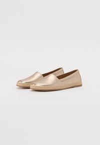 Metalické zlaté slip-on boty s zaoblenou špičkou, texturovaným textilním svrškem a tkanou jute-style podrážkou. Jednoduchý a plochý design.