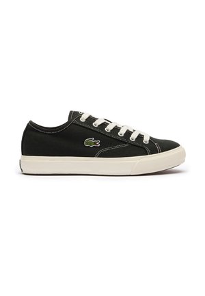 Baskets basses noires avec lacets et semelle blanches, arborant un logo crocodile vert sur le côté et des détails de coutures blanches.