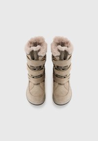 Beige vinterstövlar med en mjuk, foder av päls upptill, tre justerbara spännen och en texturerad mockafinish. Rund tå och platt gummisula.