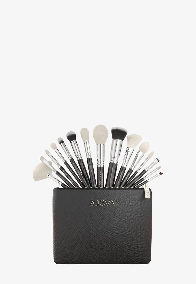 Ensemble de 15 pinceaux de maquillage à manches noirs avec poils blancs disposés en éventail, dans une pochette noire zippée étiquetée "Zoeva."
