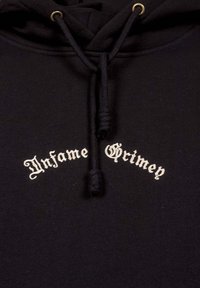 Black hoodie featuring a drawstring with gold hardware, displaying white text that reads "Infame Grimen" in a decorative font.