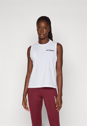 Top atlético sin mangas de color blanco con el logo "TERREX", acompañado de leggins burdeos con un logo similar, exhibiendo una textura suave.