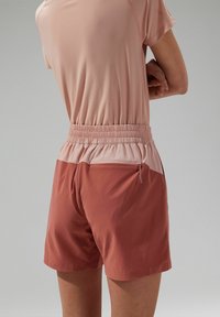 Shorts met een elastische tailleband, in koraal met een lichtere bovenkant, voorzien van een ritssluitingzak aan de zijkant en gemaakt van een soepele, lichte stof.