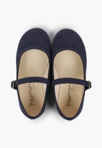 Zapatos de ante azul marino con punta redondeada, bordes festoneados y una correa con una hebilla dorada. El interior cuenta con un forro beige y una etiqueta de la marca.