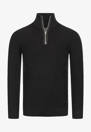 Jersey de punto negro con un alto cuello y una cremallera corta. Presenta una textura acanalada y mangas largas. Destacado con un pequeño detalle de logo.