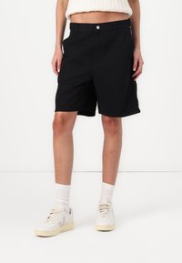 Sorte shorts lavet af letvægtsstof med lige snit. Har en lukning med frontknap og sidelommer. Pænt kantet afslutning.