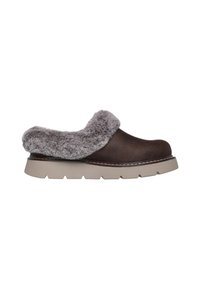 Zapato marrón sin cordones con un suave cuello de piel sintética gris, un upper liso y una suela de goma gruesa y gris claro con un patrón texturizado.
