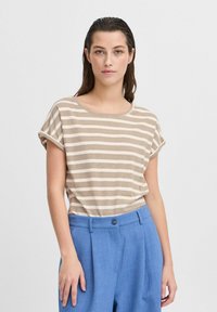 T-shirt rayé en beige et crème, avec des manches courtes retroussées et un col large, assorti à un pantalon léger bleu sur mesure.