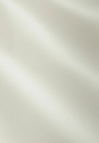 Simogató, puha anyag törtfehér színben, finom, átlós mintázatú textúrával, lágyan redőződve.