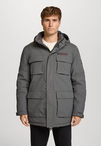 Parka grise isolée avec capuche, quatre poches avant et fermeture éclair frontale. Comprend un détail logo et une doublure intérieure douce.