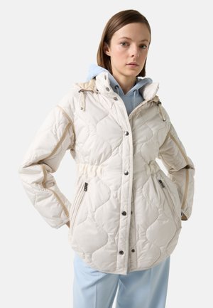 White quilted jacket with a hood, featuring gold accents, press studs, and side pockets, worn over a light blue hoodie.