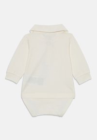 Cremfarbener Langarm-Babykörper mit Kragen, Rückansicht, mit Druckknöpfen am Boden für einen einfachen Windelwechsel.