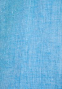 Lichtblauwe stof met een gladde textuur, met een subtiel geweven patroon. Het materiaal lijkt licht van gewicht en luchtig te zijn.