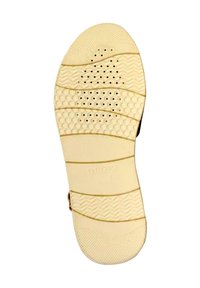 Semelle de chaussure en caoutchouc beige avec des motifs texturés, y compris des rainures horizontales et de petits trous de ventilation. Logo "GEOX" embossé au centre.