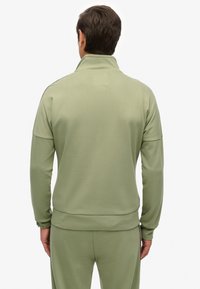 Lichtgroene fleece trui met een hoge kraag, geribde manchetten en tailleband. Gladde textuur, minimalistisch ontwerp, geen zichtbare logo's.