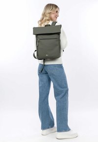 Sac à dos olive enroulable avec poche avant zippée, bretelles ajustables et design minimaliste. Fabriqué en tissu durable.