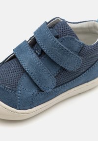 Blue suede and mesh shoe with Velcro straps; features a textured upper and a lightweight, white rubber sole.